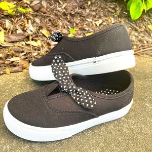 Girls black slip on canvas shoe with polka dot bow